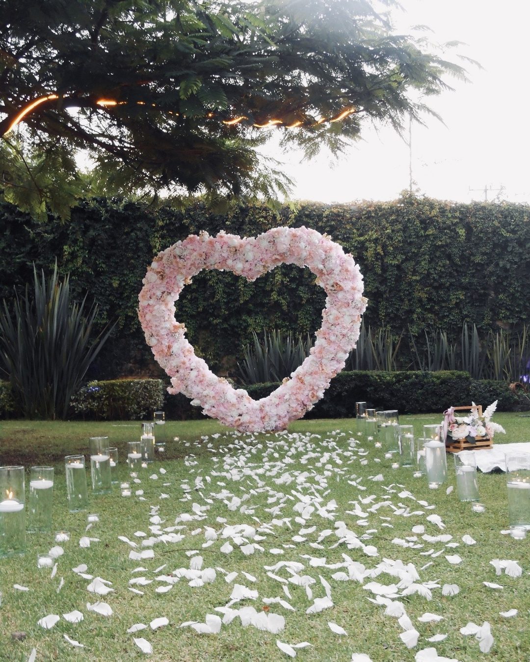 Corazón de flores sobre el pasto del jardín de Salón Terraza Bonanza, en Tonalá, con camino de pétalos y velas